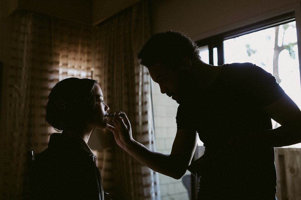 silhouette of a bride getting her makeup done