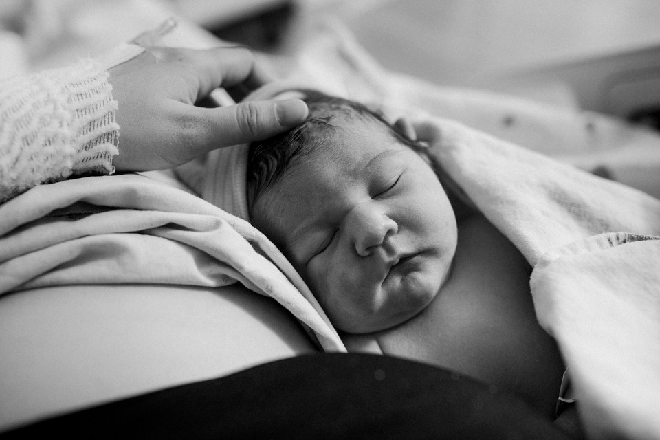 mom holding her brand new baby in the hospital