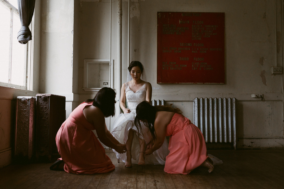 bridesmaids helping the bride with her shoes