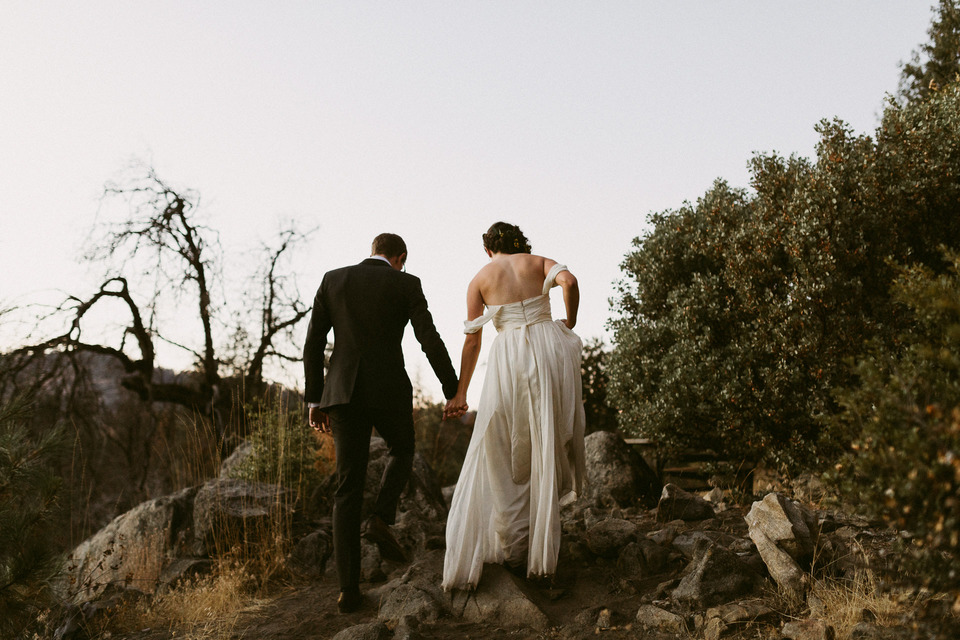 bride and groom hiking through sierra nevadas at sunset